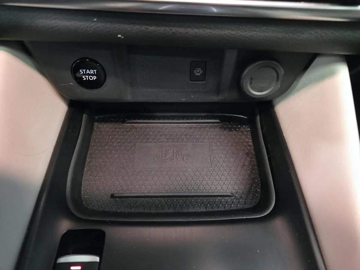 Détail de la console centrale du Nissan Qashqai 2024, montrant le chargeur à induction et le bouton Start/Stop.