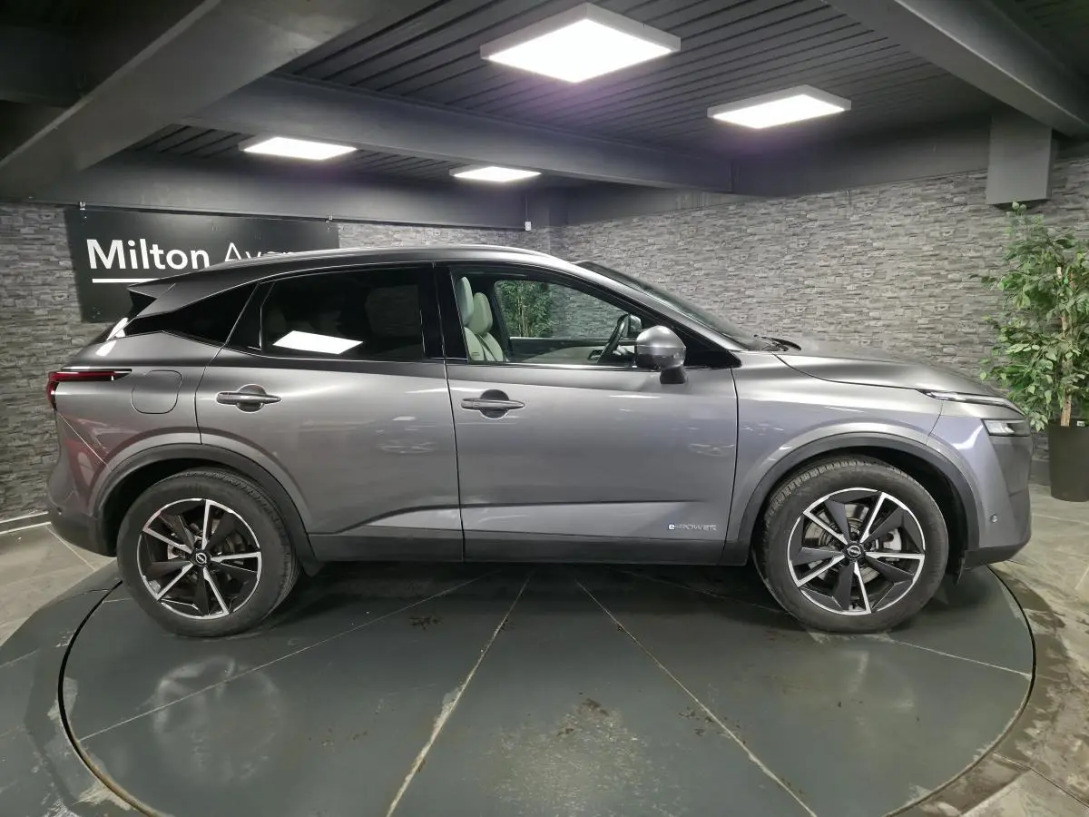 Vue de profil côté gauche d'un Nissan Qashqai gris métallisé avec jantes alliage 19 pouces et badge e-Power visible.