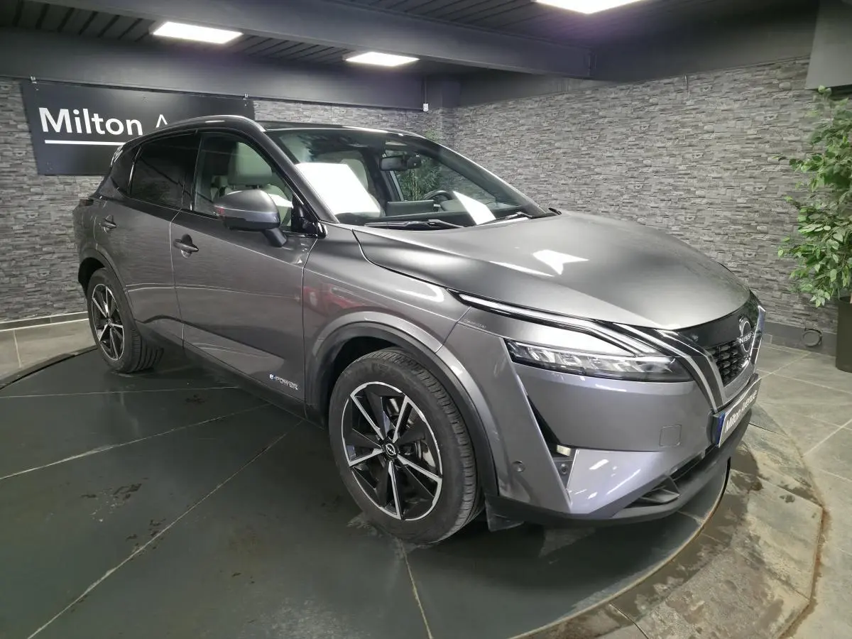 Nissan Qashqai 1.5 e-Power gris métallisé en vue 3/4 avant droit avec toit panoramique et jantes alliage 19 pouces.