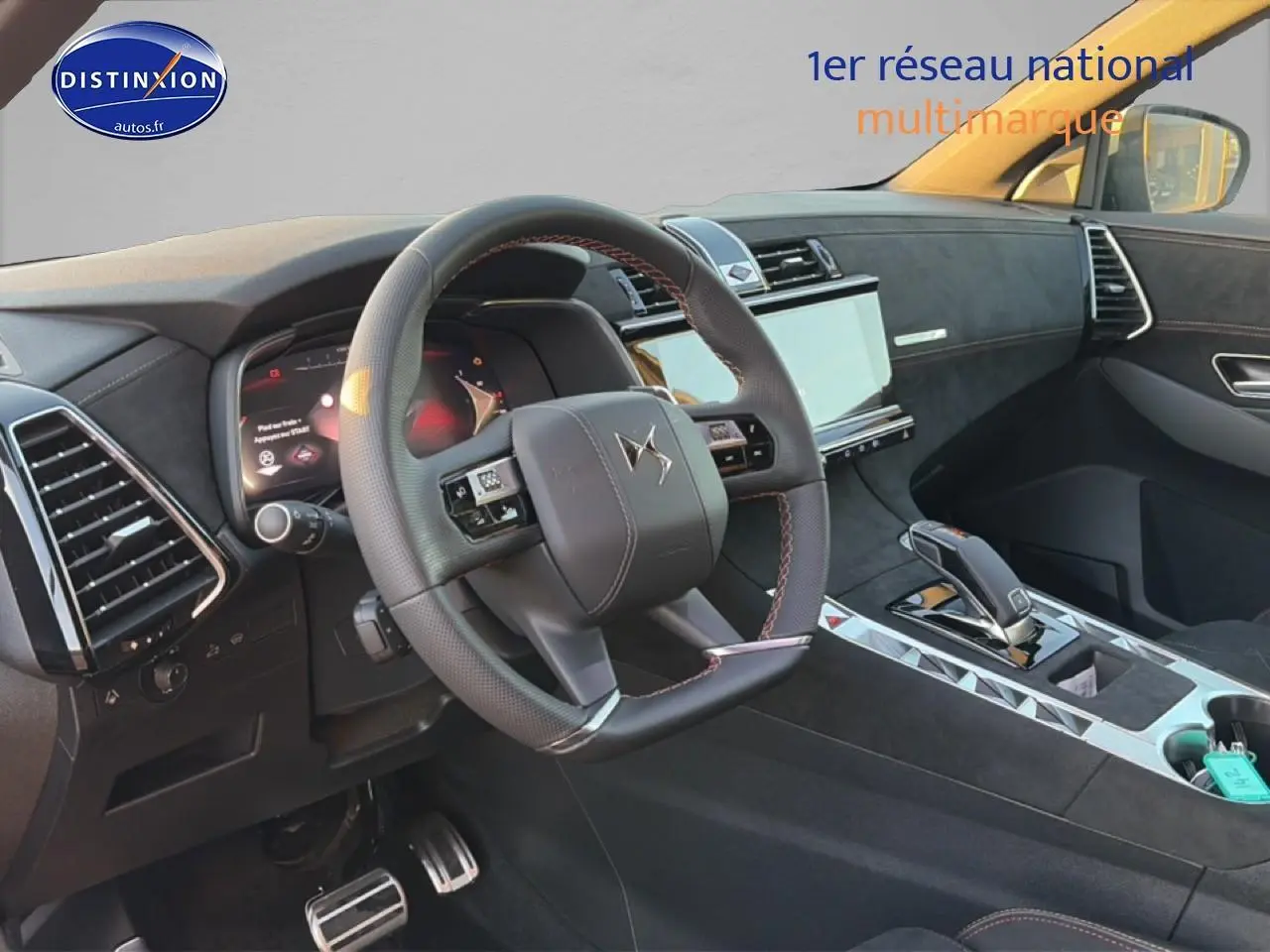 Vue intérieure côté conducteur du DS7 1.5 BlueHDi 130 noir, volant cuir avec surpiqûres rouges et écran tactile central.
