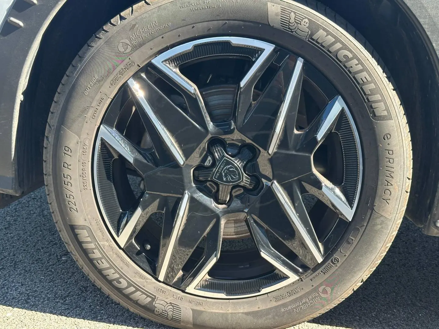 Gros plan sur la jante alu noire et argentée du côté gauche d’un Peugeot 5008 blanc Okénite.