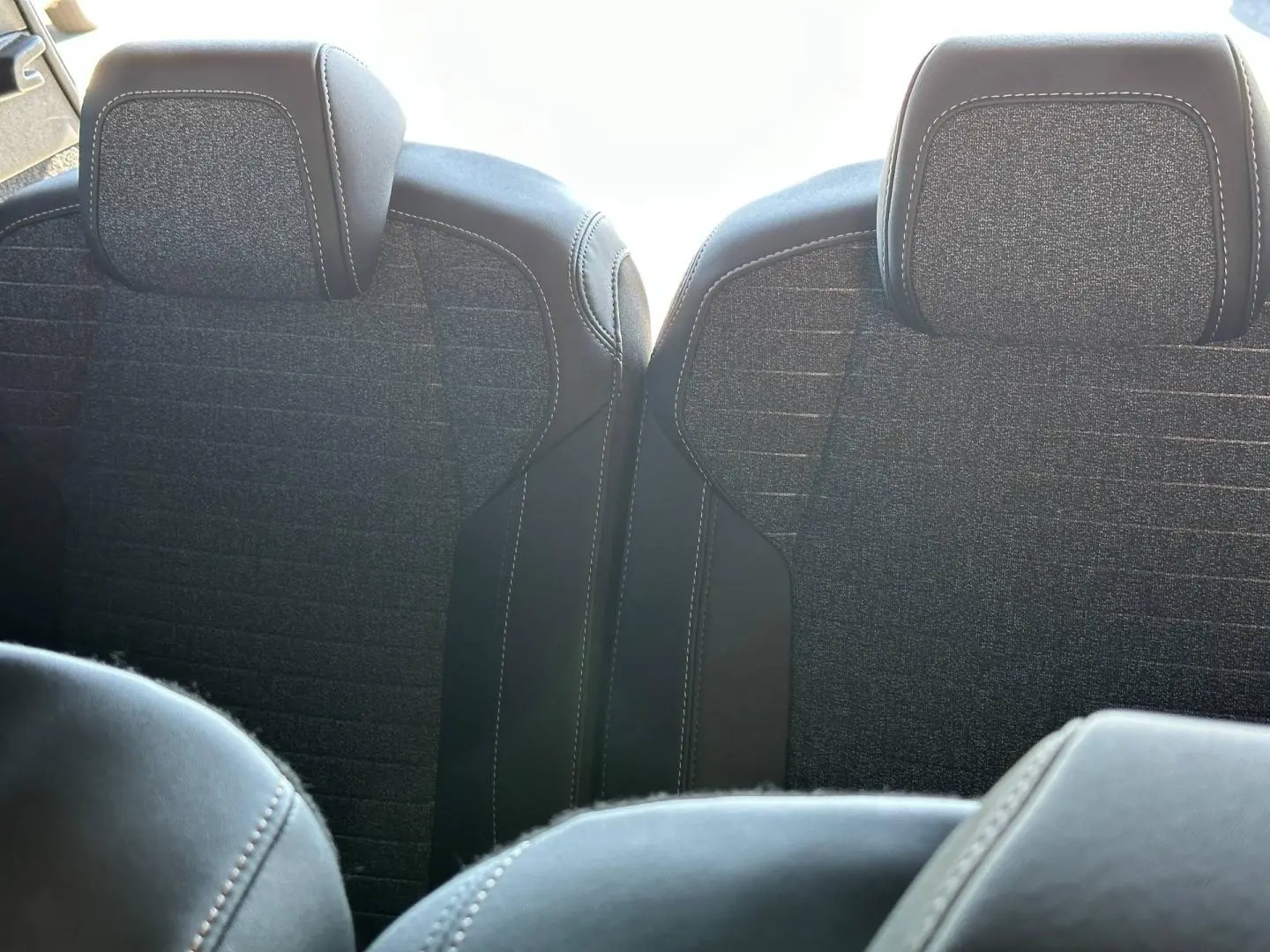 Vue rapprochée des sièges arrière en tissu gris et cuir noir du Peugeot 5008 Hybrid 145ch Allure 2025.