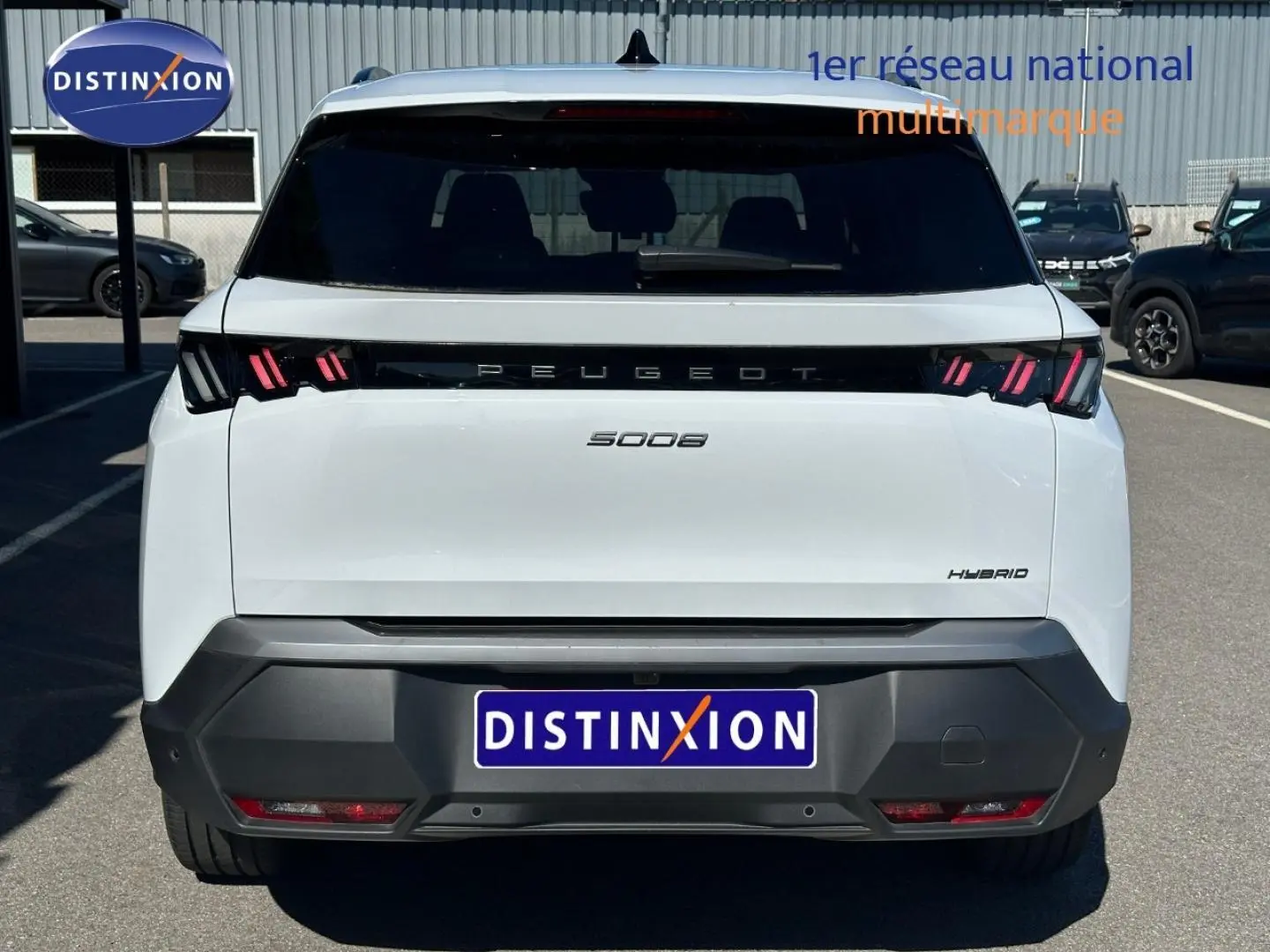 Vue arrière d'un Peugeot 5008 Hybrid blanc Okénite avec feux LED distinctifs et logo Peugeot noir.