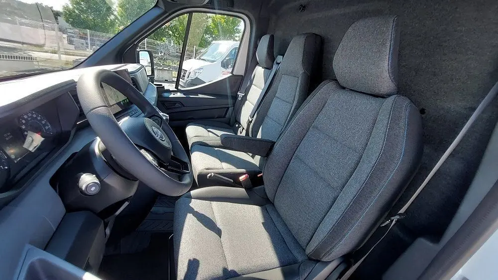 Vue intérieure côté conducteur du Nissan Interstar Fourgon 2025, sièges gris et tableau de bord moderne.
