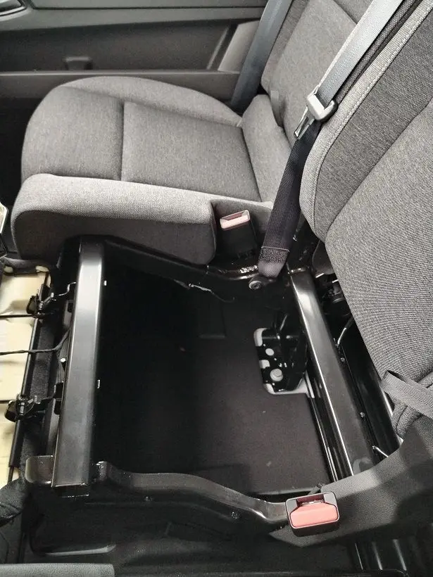 Vue rapprochée de l'intérieur côté passager du Nissan Interstar Fourgon 2026, siège gris avec rangement sous l'assise ouvert.