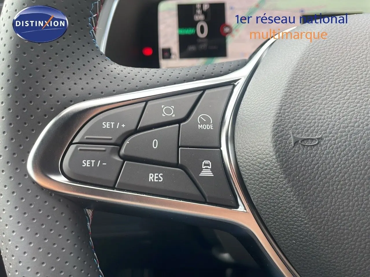 Gros plan sur les commandes au volant du Renault Captur E-Tech hybride 2025, cuir noir perforé avec surpiqûres tricolores.