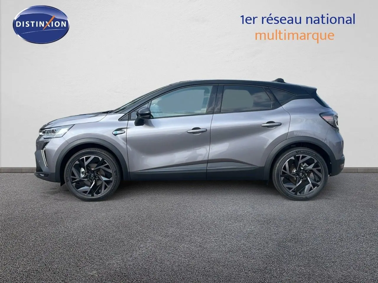 Profil côté gauche du Renault Captur E-Tech hybride 2025 gris cassiopée avec toit noir et jantes noires distinctives.