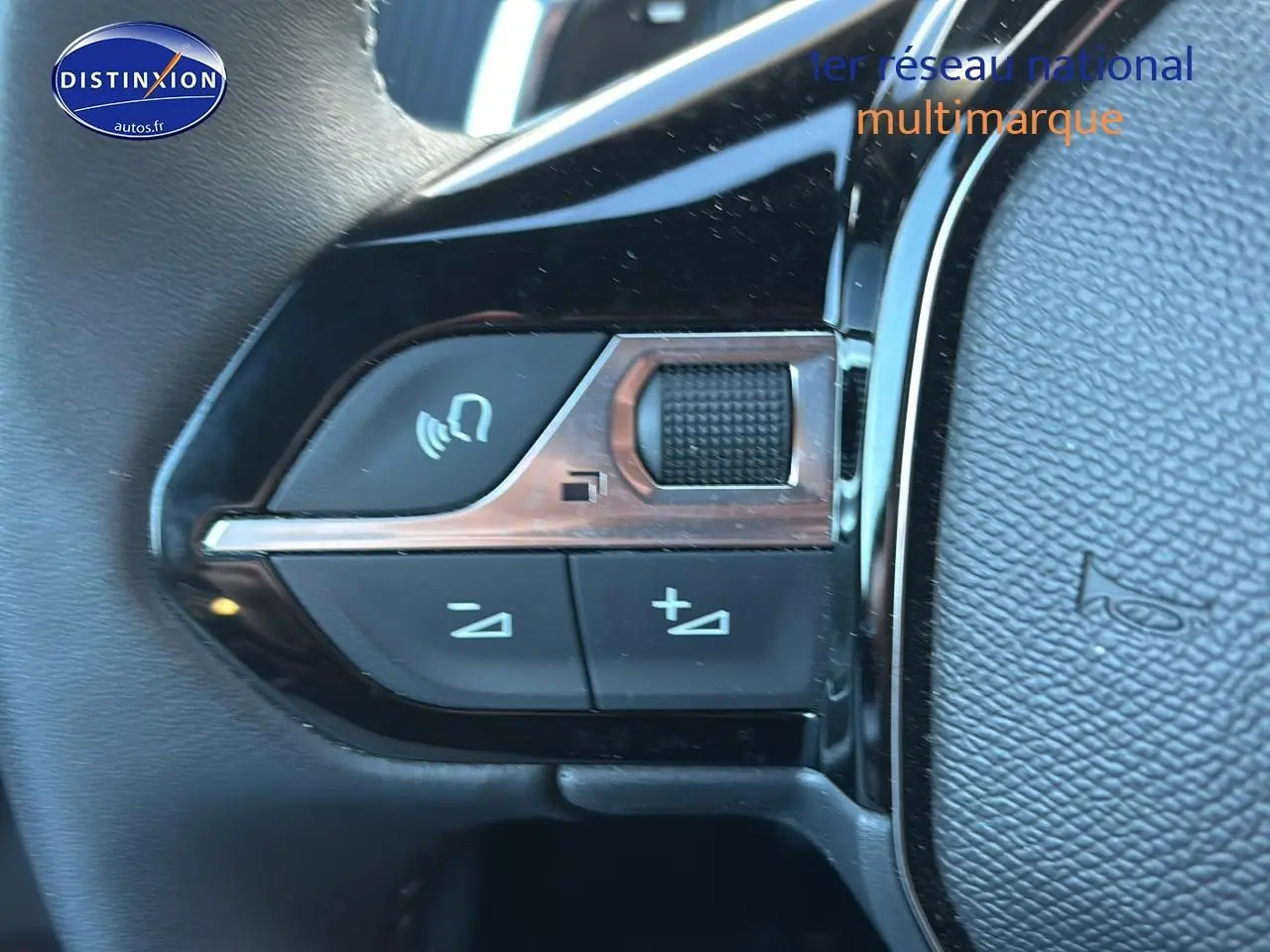 Gros plan sur les commandes de volume et appel du volant noir du Peugeot 2008 1.2 hybrid 145 allure e-dcs6.