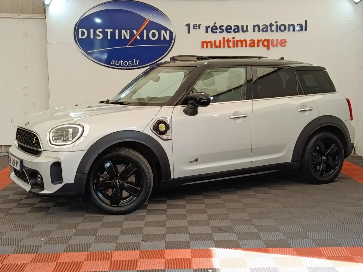 Vue de profil droit d'une MINI Countryman Cooper SE hybride rechargeable blanche avec toit noir et jantes noires.
