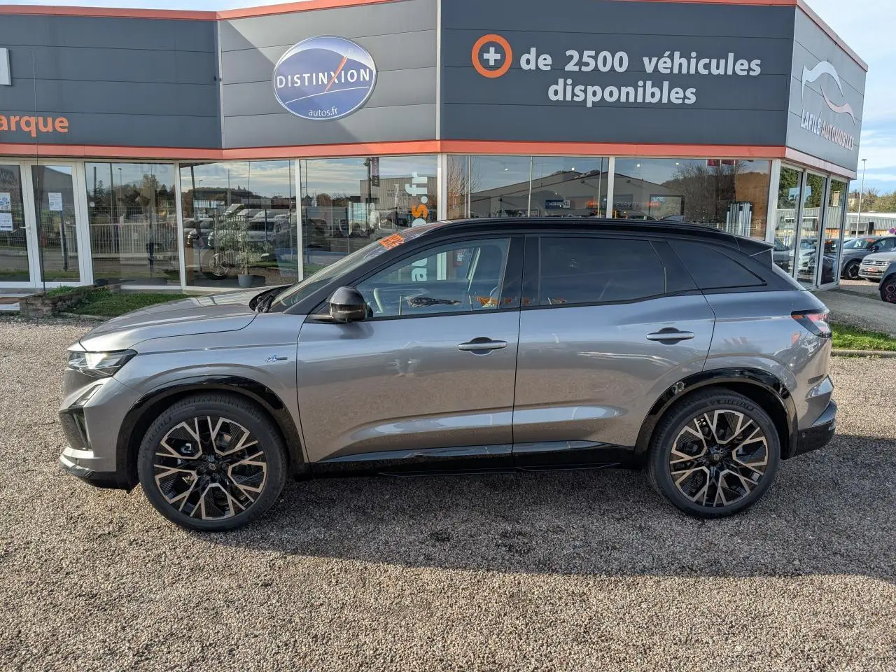 Profil droit du Renault Austral gris métallisé avec toit noir étoilé et jantes alliage 20 pouces diamantées.