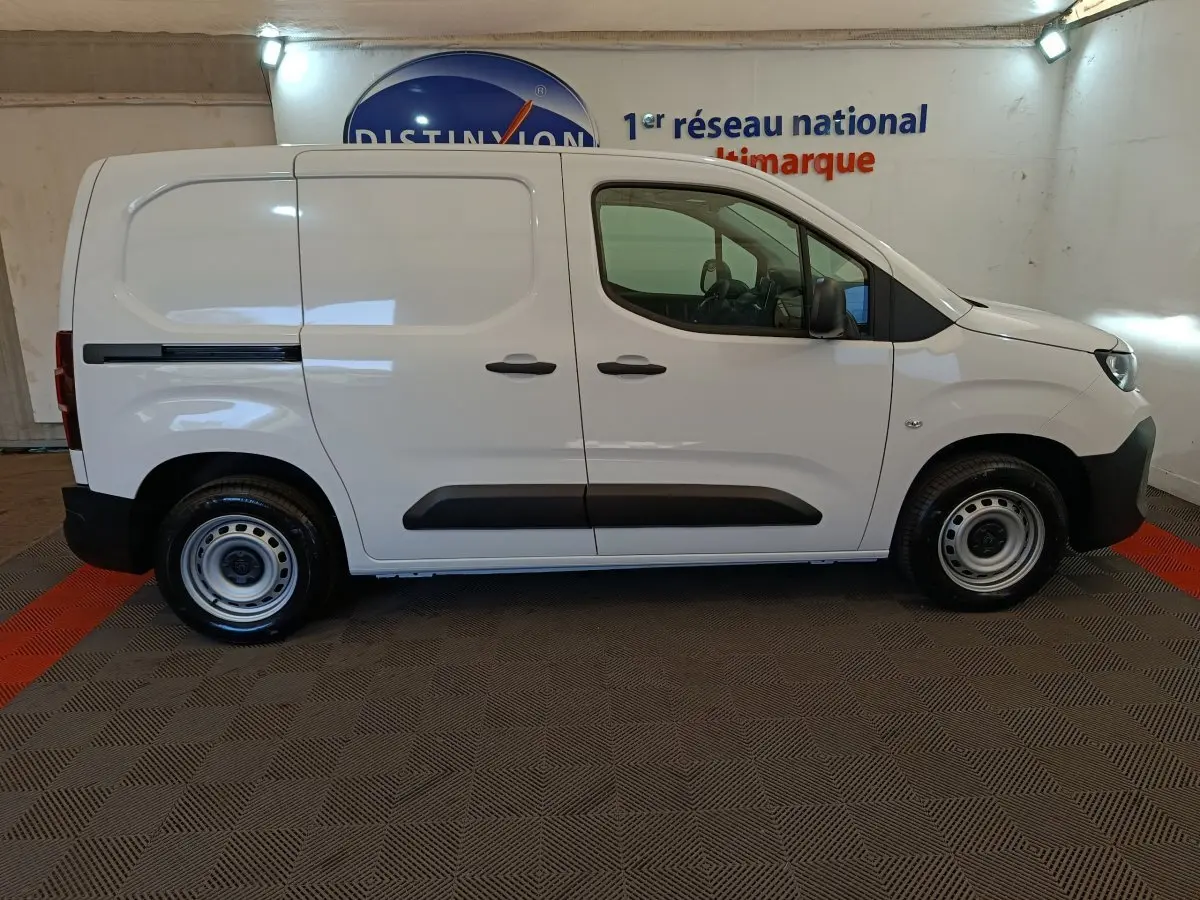 Vue de profil côté droit du Peugeot Partner blanc 2025, utilitaire compact avec protections latérales noires.