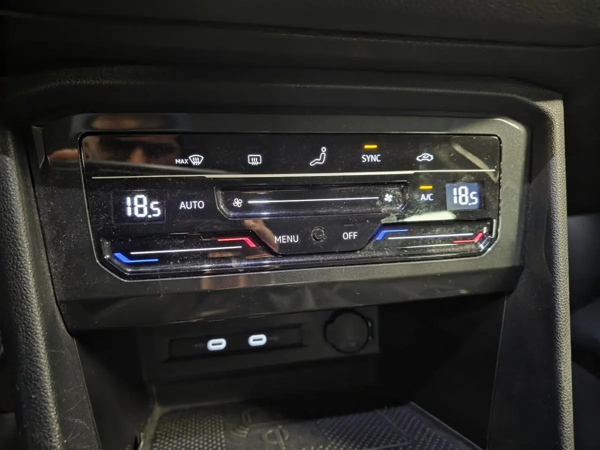 Panneau de climatisation automatique tri-zone avec affichage digital et deux ports USB-C dans un Volkswagen Tiguan gris 2023.