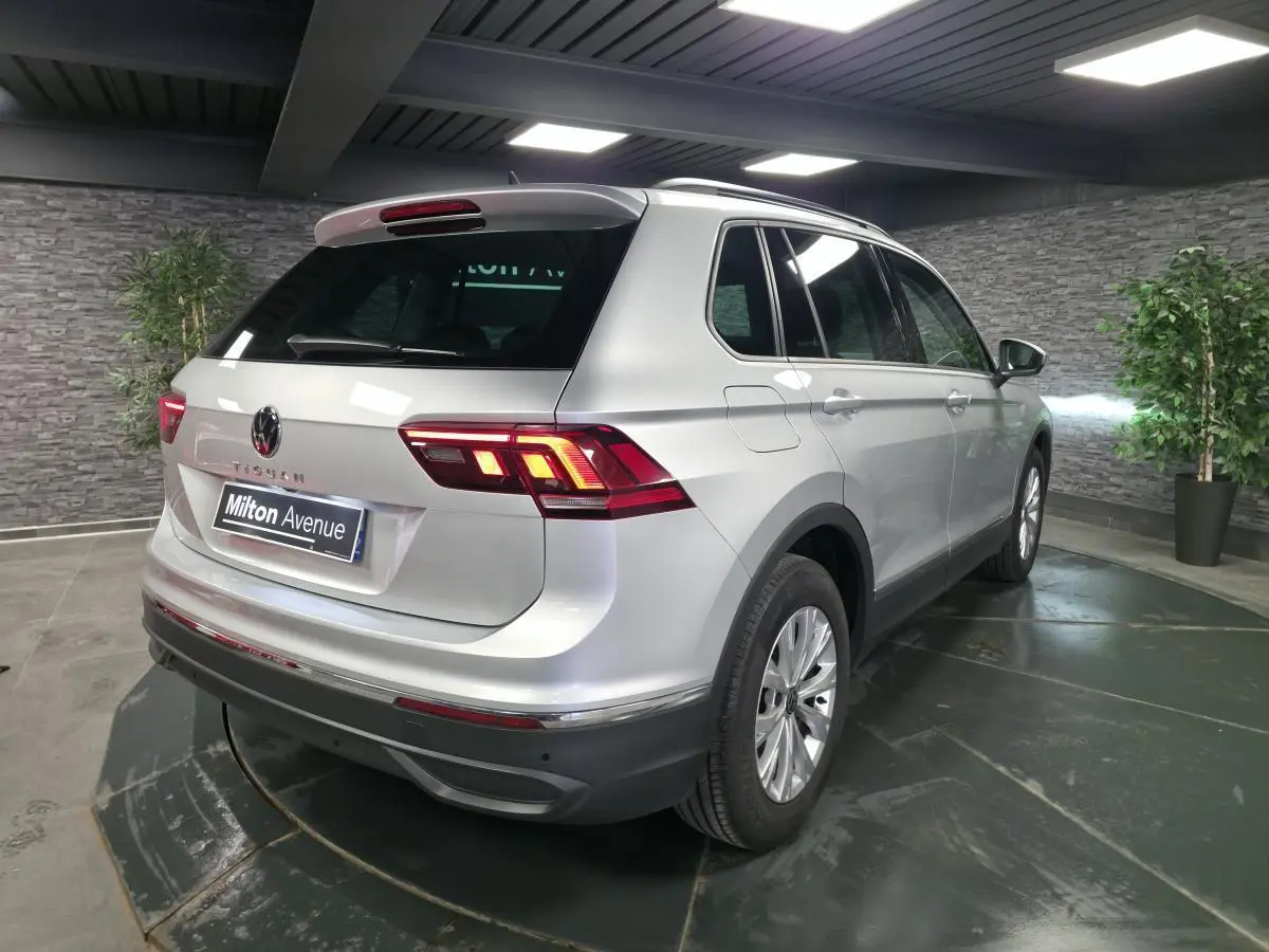 Vue 3/4 arrière droit d'un Volkswagen Tiguan gris métallisé 2023 avec feux LED et jantes alliage 17 pouces.