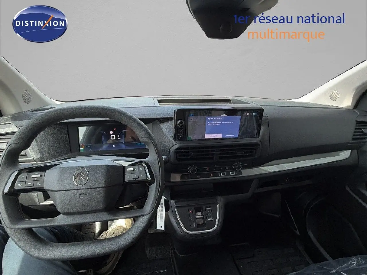 Vue intérieure avant du Citroën Jumpy blanc Kaolin, tableau de bord moderne avec écran tactile et volant multifonction.