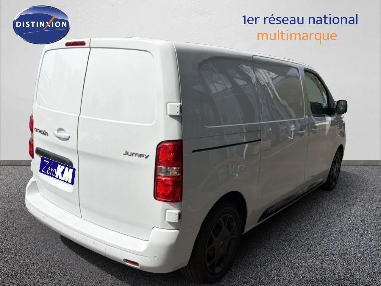 Vue 3/4 arrière droite d’un Citroën Jumpy blanc Kaolin, fourgon utilitaire avec vitres latérales teintées et feux rouges.