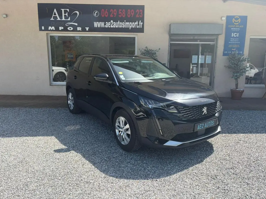 Peugeot 3008 noir vue 3/4 avant, avec calandre distinctive et jantes alliage, stationné devant un garage AE2 Autos Import.