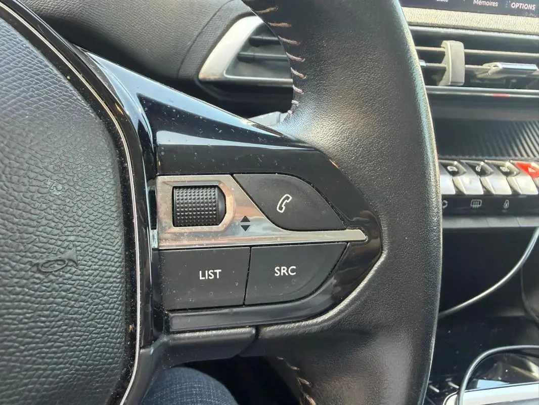 Gros plan sur la partie gauche du volant noir du Peugeot 3008 2021, avec commandes audio et téléphone visibles.