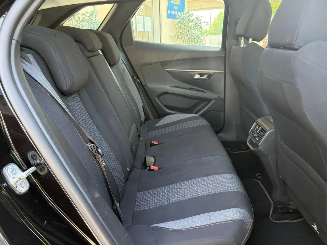 Vue intérieure côté gauche des sièges arrière noirs du Peugeot 3008 2021, montrant les ceintures et la porte ouverte.