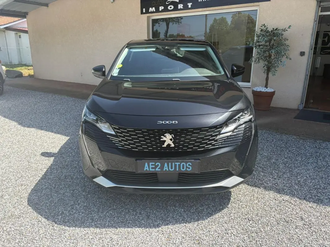 Vue de face d'un Peugeot 3008 noir 2021 avec calandre distinctive et logo lion visible sur un parking extérieur.