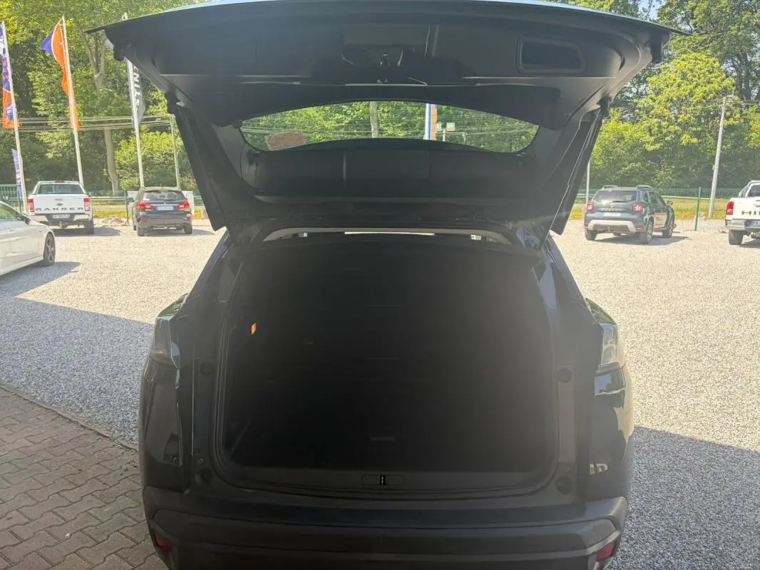 Vue arrière du Peugeot 3008 noir 2021 avec coffre ouvert, mettant en valeur l'espace de chargement vide.