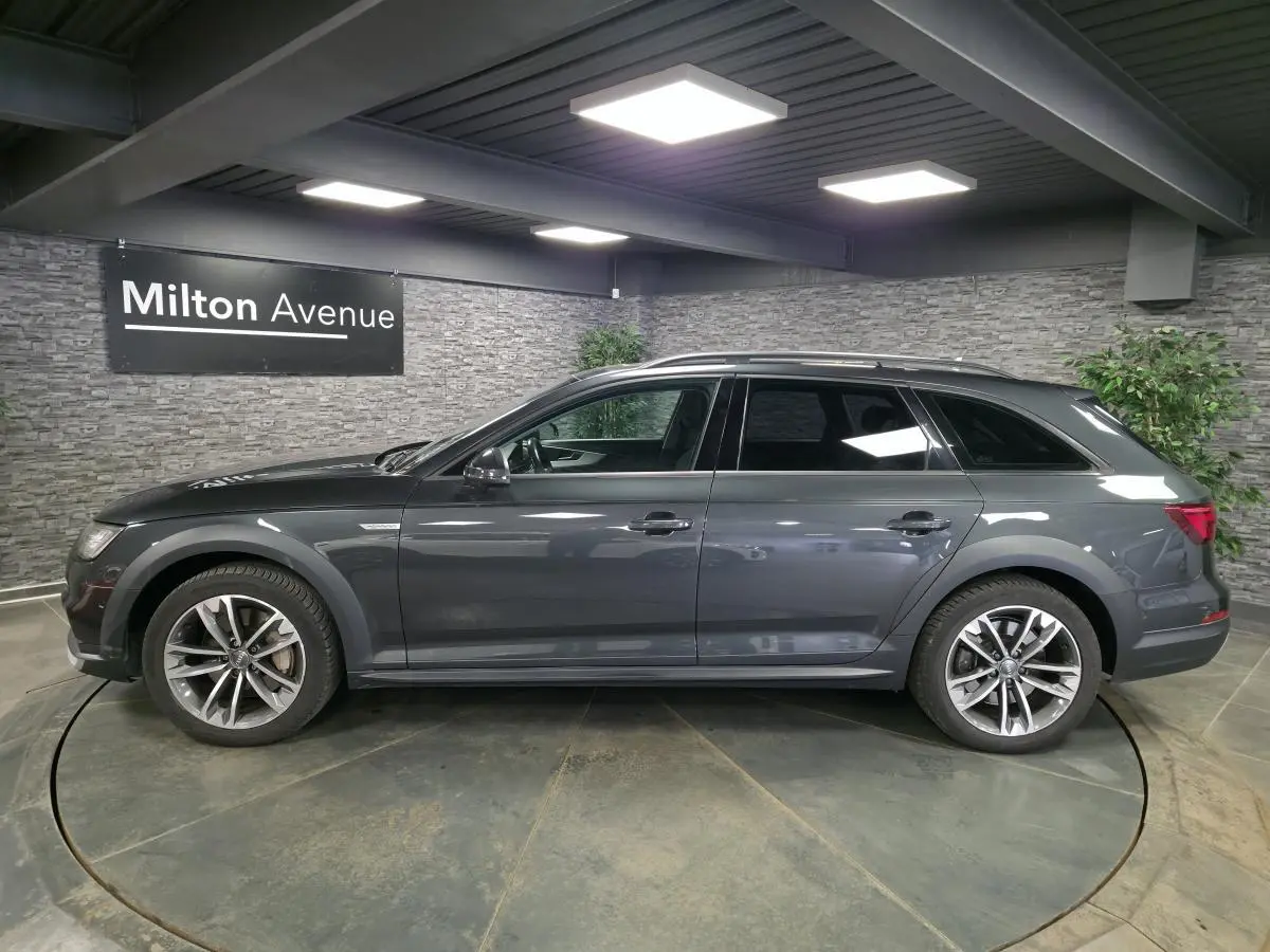 Audi A4 Allroad Quattro gris en profil droit, avec jantes aluminium 5 branches doubles et toit panoramique.