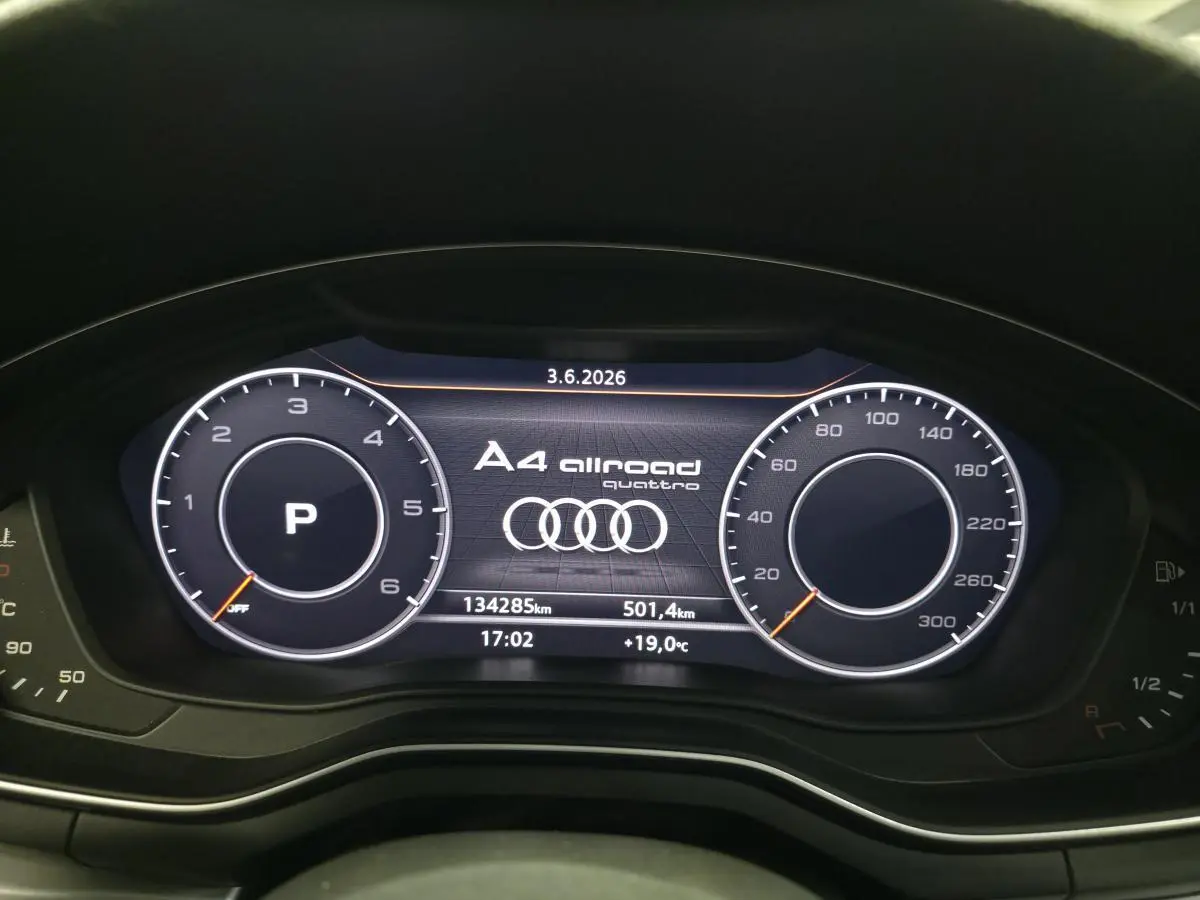 Vue rapprochée du tableau de bord numérique de l'Audi A4 Allroad gris, affichant compteurs et logo Quattro.