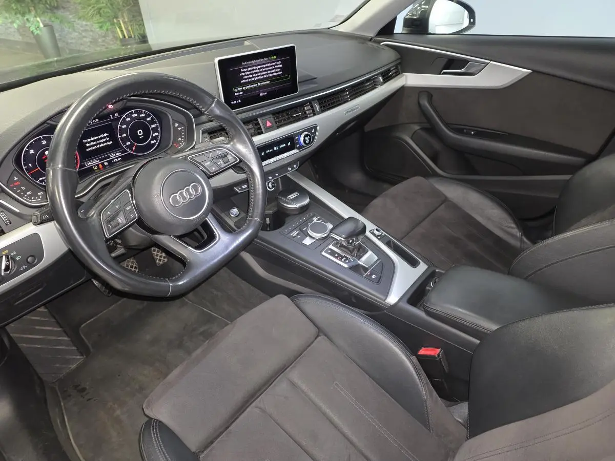 Vue intérieure côté conducteur de l'Audi A4 Allroad 2017 avec sellerie cuir/Alcantara noire et tableau de bord moderne.