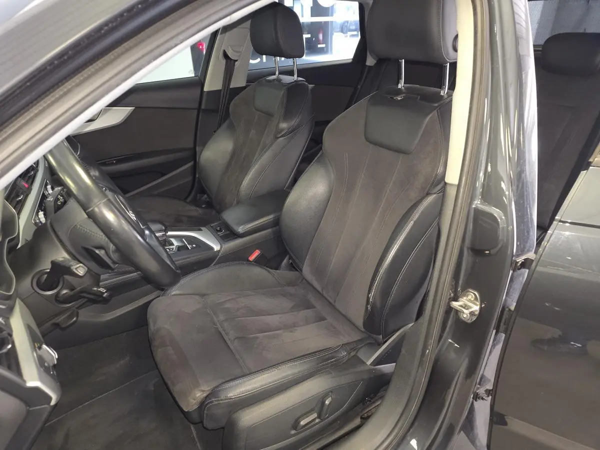 Vue intérieure côté conducteur de l'Audi A4 Allroad gris, mettant en valeur les sièges sport cuir/Alcantara et la console centrale.