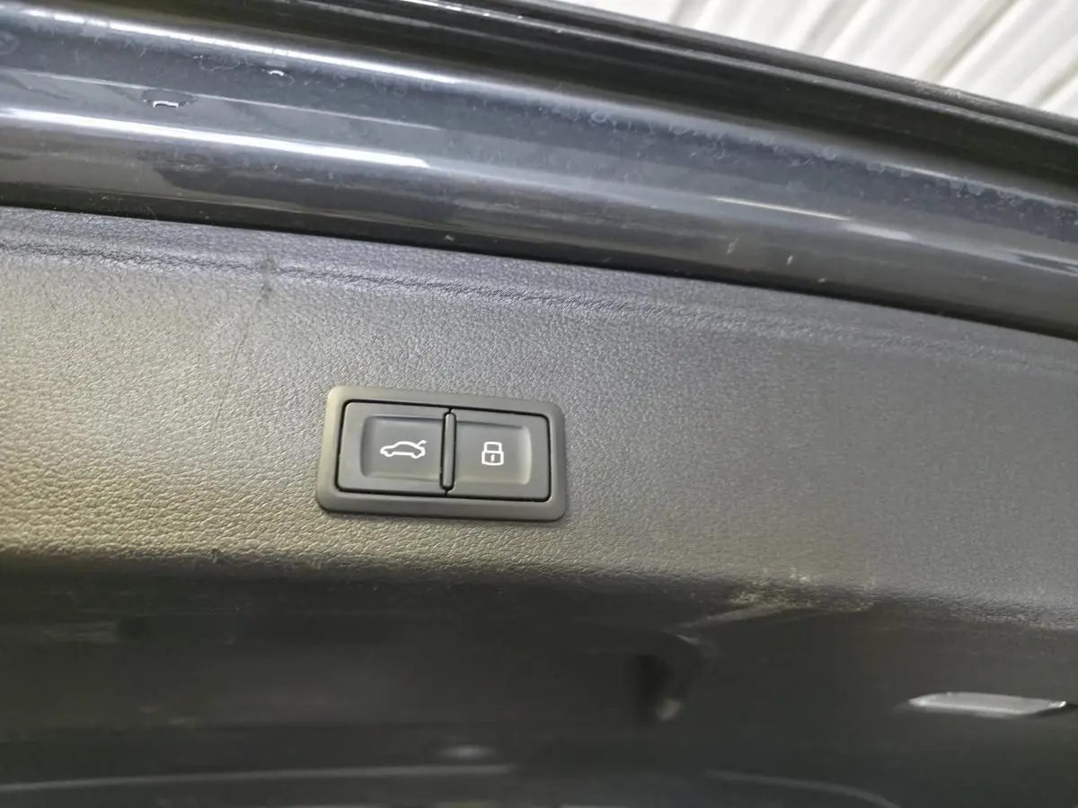 Boutons de commande pour ouverture et verrouillage du coffre sur le hayon intérieur d'une Audi A4 Allroad gris.