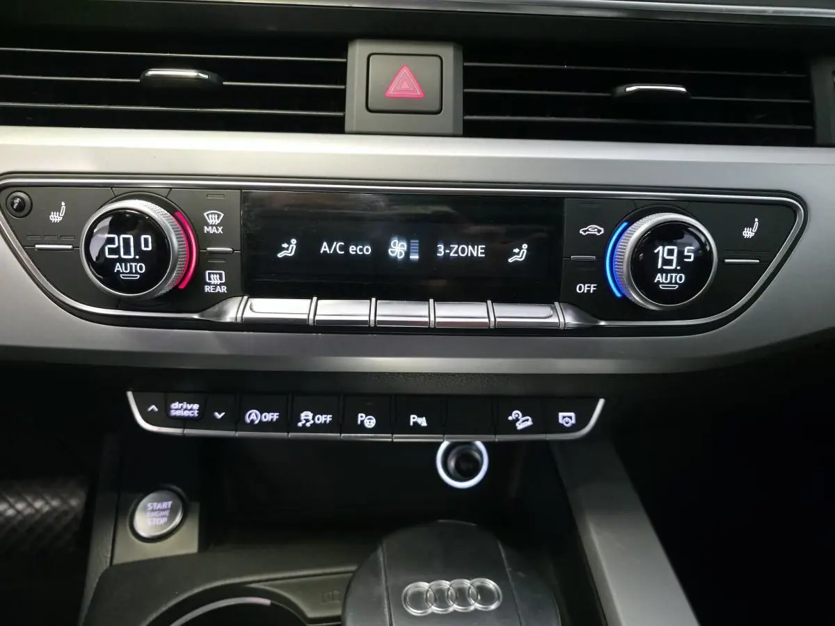 Vue rapprochée de la console centrale de l'Audi A4 Allroad 2017, affichant la climatisation automatique 3 zones et les commandes multifonctions.