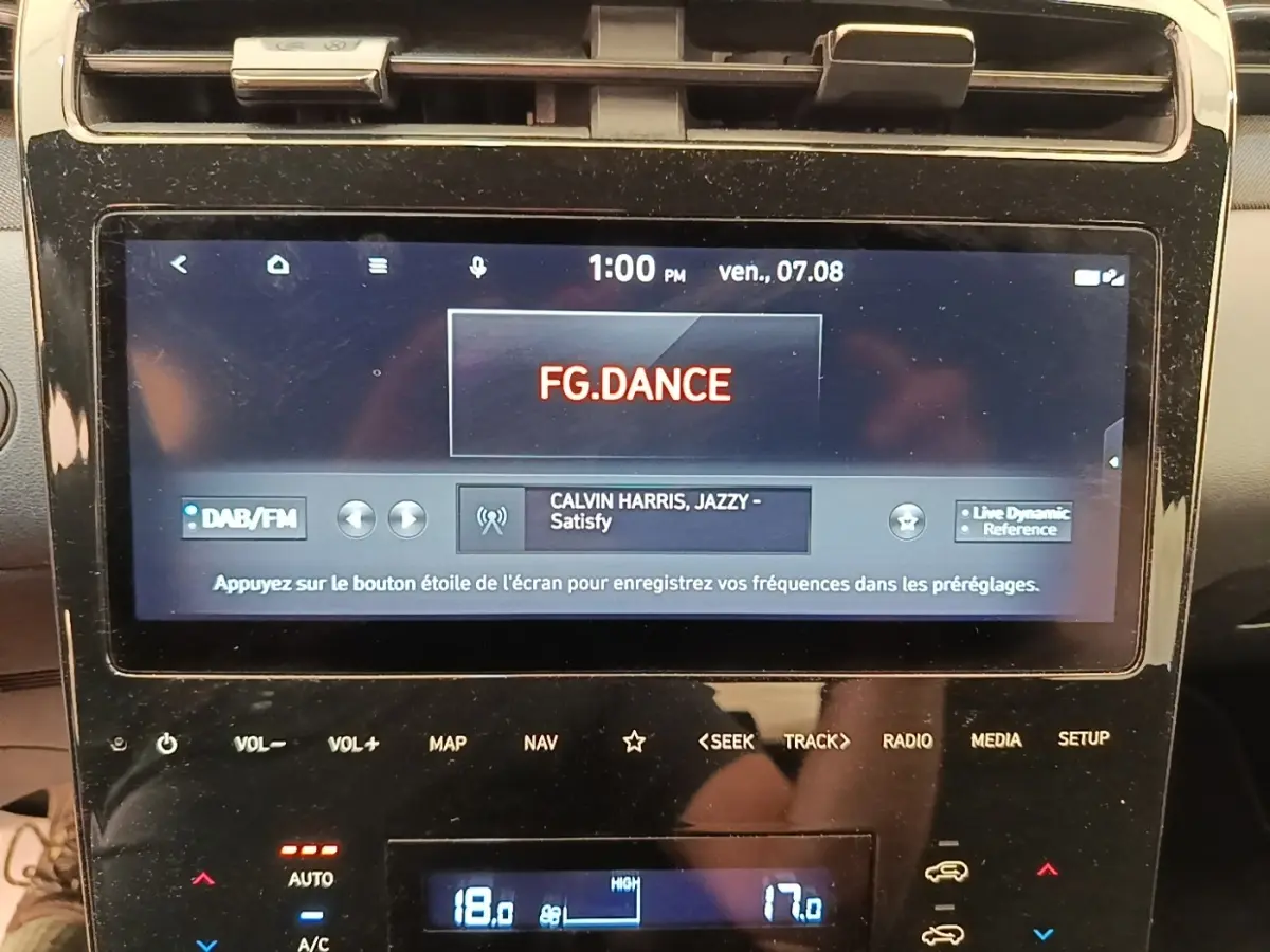 Écran tactile central du Hyundai Tucson rouge 2022 affichant la radio et commandes multimédia.