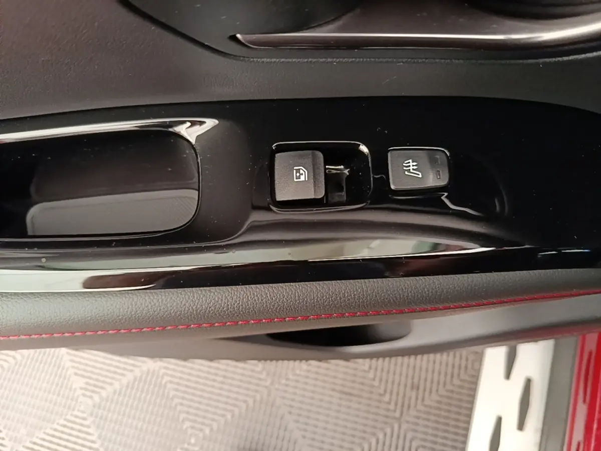 Détail de la commande de verrouillage et siège chauffant sur la porte intérieure d’un Hyundai Tucson rouge.