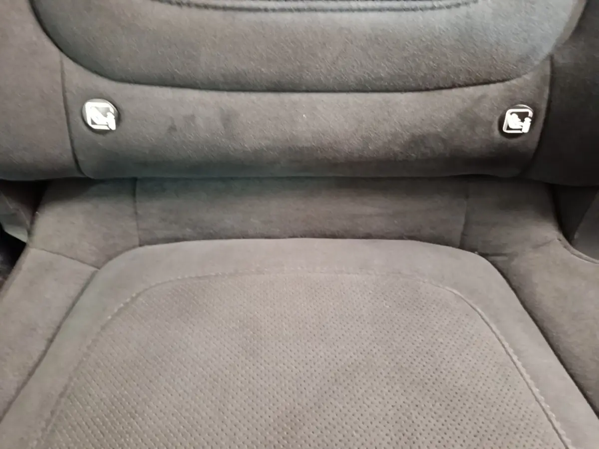 Détail du siège arrière en tissu gris foncé avec ancrages ISOFIX visibles sur un Hyundai Tucson rouge.