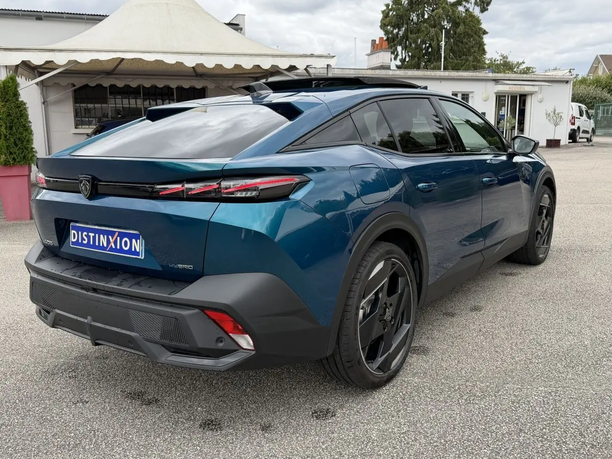 Vue 3/4 arrière droite d'une Peugeot 408 PHEV 225 GT bleu avec feux LED et jantes noires distinctives.