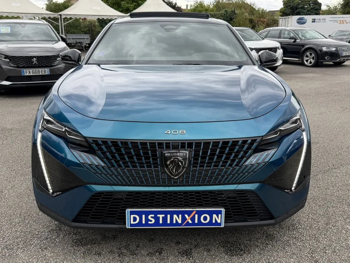 Vue avant frontale d'une Peugeot 408 PHEV 225 GT bleu avec calandre noire et feux LED verticaux allumés.