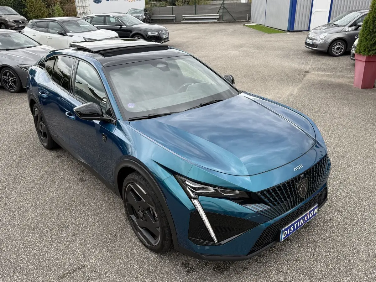 Peugeot 408 PHEV 225 GT bleu, vue 3/4 avant droit, avec calandre distinctive et phares LED en griffes.