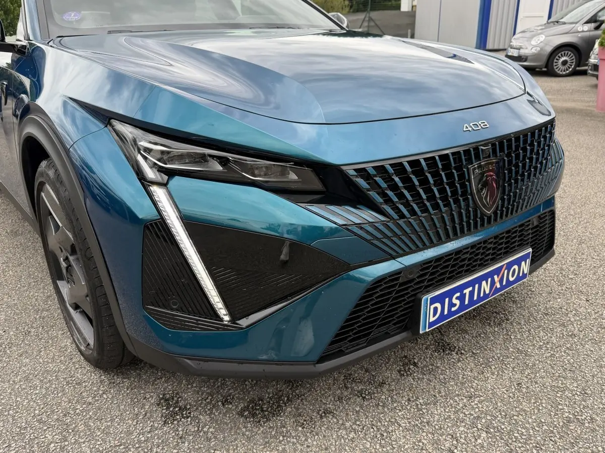Vue 3/4 avant gauche du Peugeot 408 PHEV 225 GT bleu avec calandre noire et feux LED distinctifs en forme de griffes.