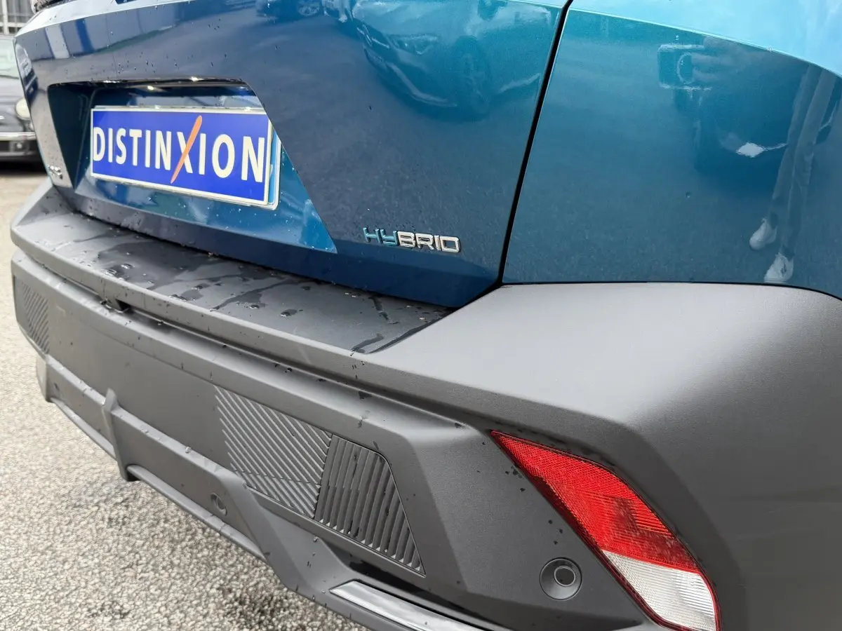 Vue rapprochée arrière droite du Peugeot 408 PHEV 225 GT bleu avec logo Hybrid et feux arrière distinctifs.