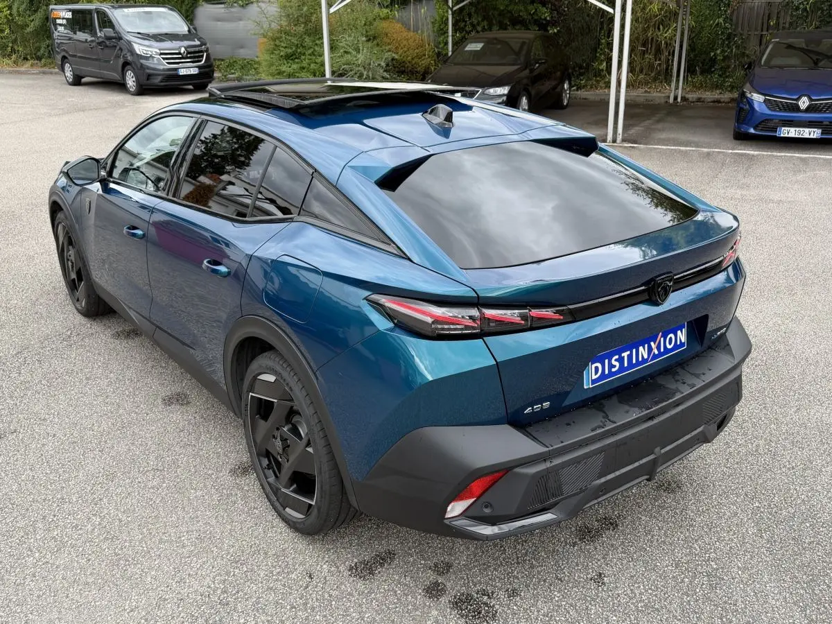 Vue 3/4 arrière droite d'une Peugeot 408 PHEV 225 GT bleu avec toit panoramique et feux arrière LED distinctifs.