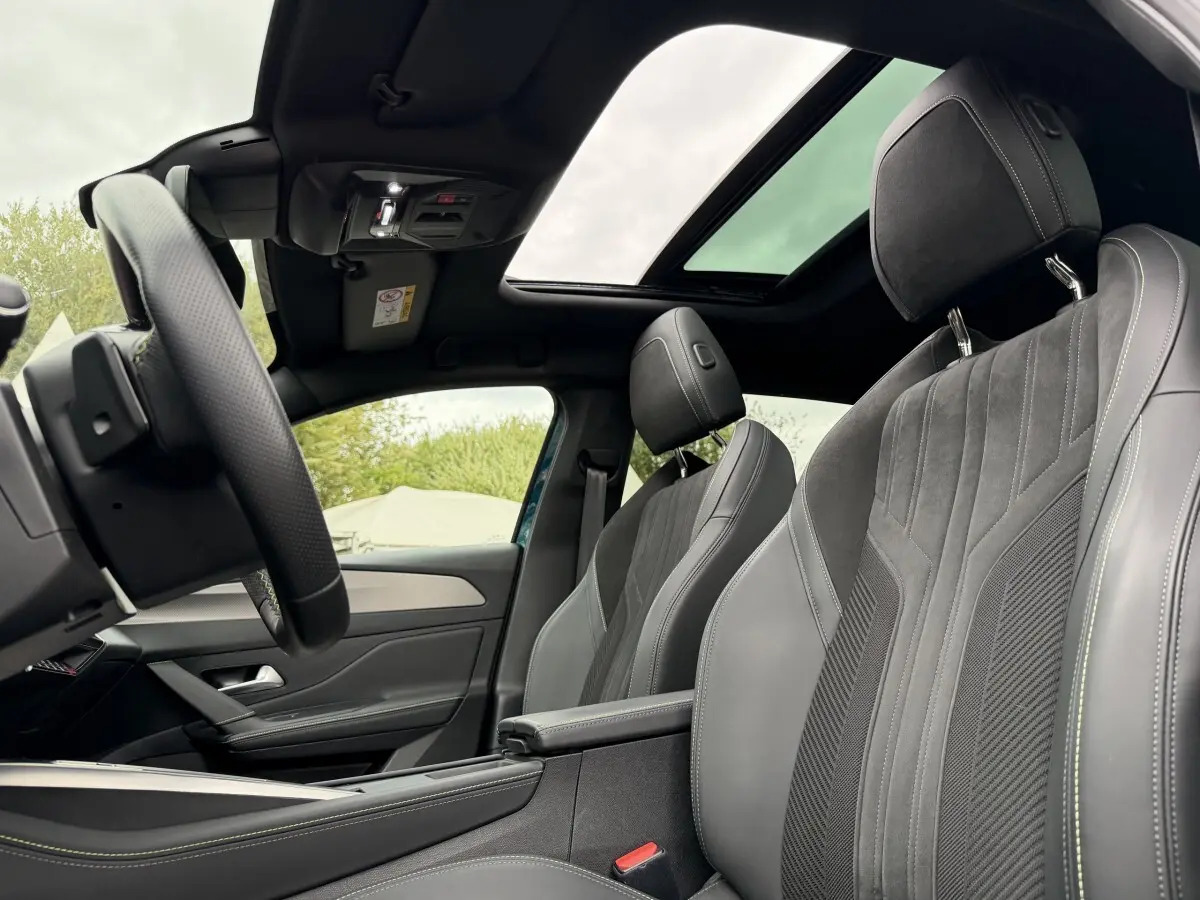 Vue intérieure côté gauche du Peugeot 408 PHEV 225 GT 2023 avec sièges gris et toit ouvrant panoramique.