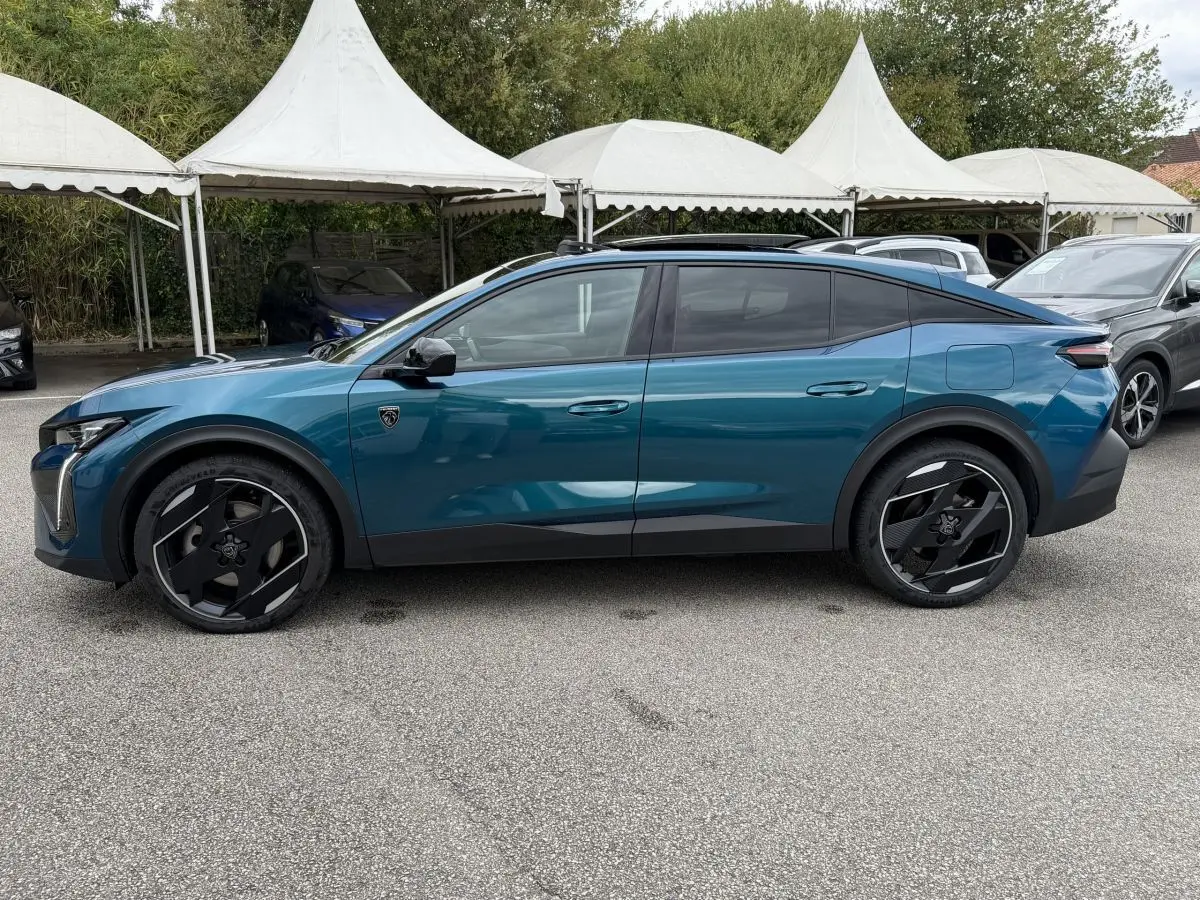 Peugeot 408 PHEV 225 GT bleu vue de profil côté gauche, avec jantes noires et toit panoramique ouvert.