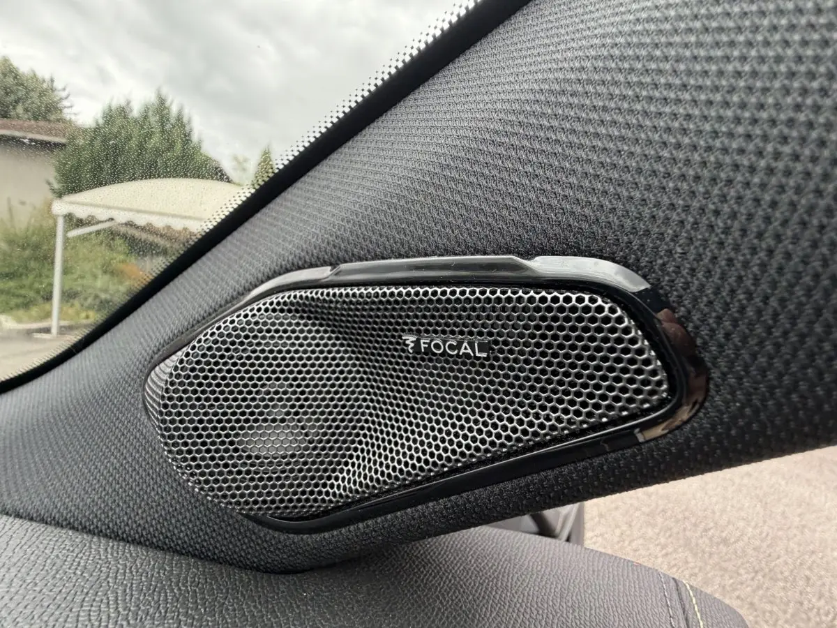 Gros plan sur l'enceinte Focal intégrée côté gauche dans l'habitacle d'une Peugeot 408 bleu 2023.