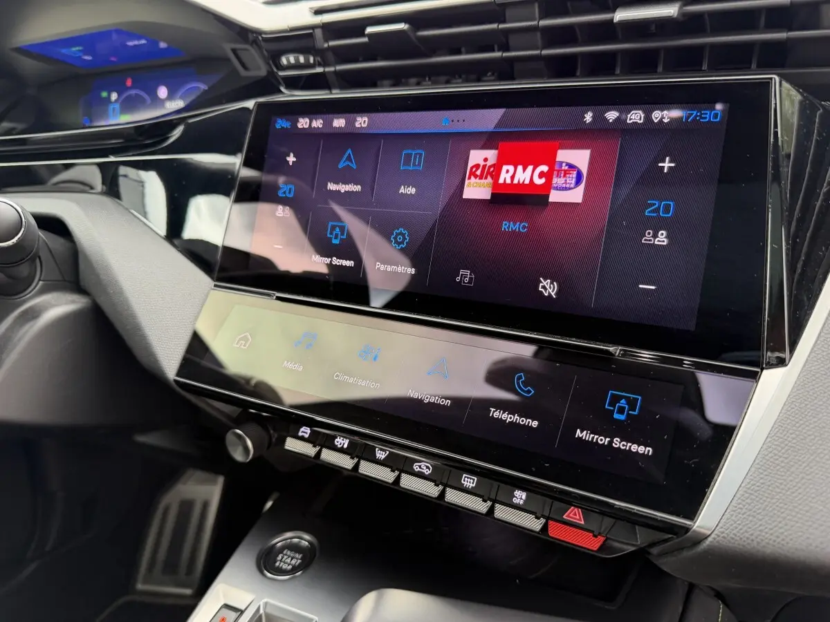 Vue rapprochée de la console centrale tactile du Peugeot 408 PHEV 225 GT 2023, affichage multimédia et climatisation.