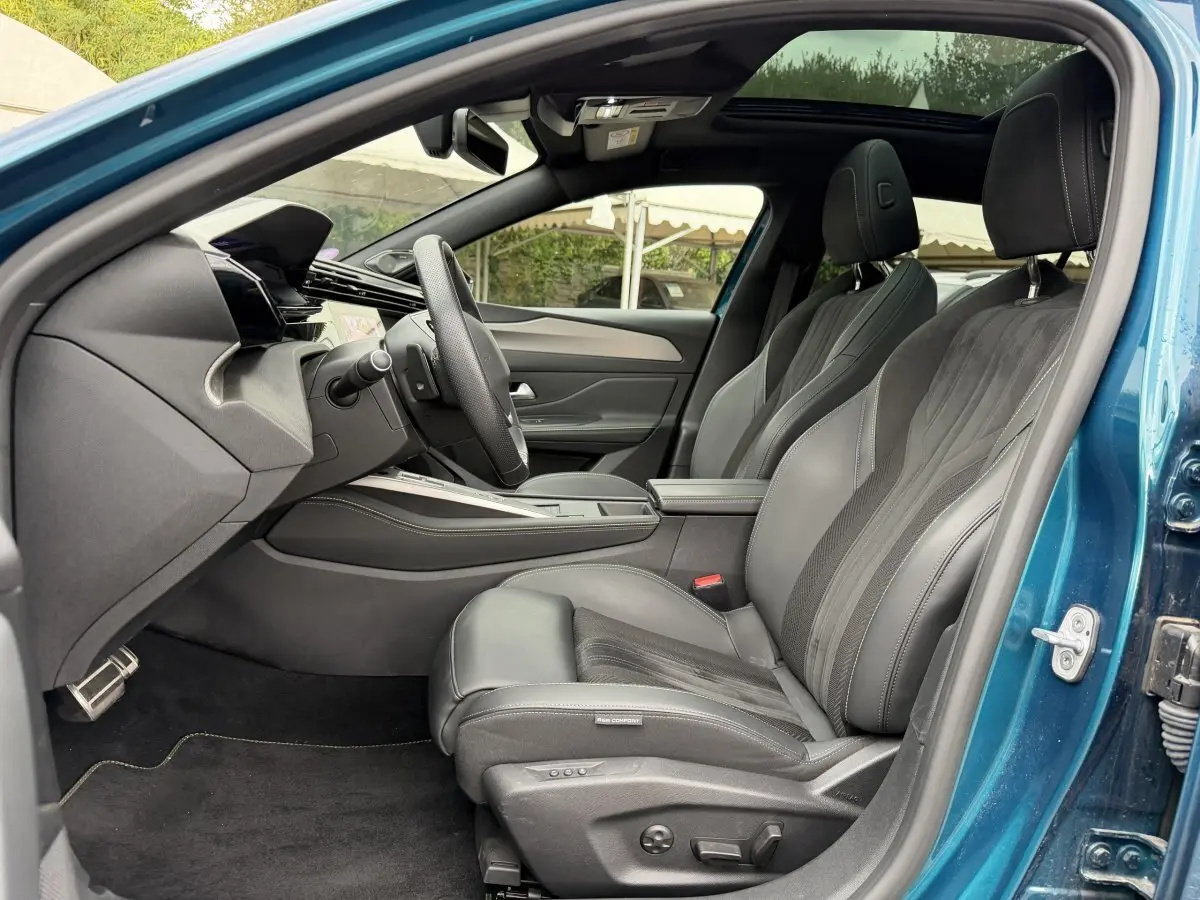 Intérieur côté conducteur bleu Peugeot 408 PHEV 225 GT 2023, sièges cuir noirs et tableau de bord moderne.