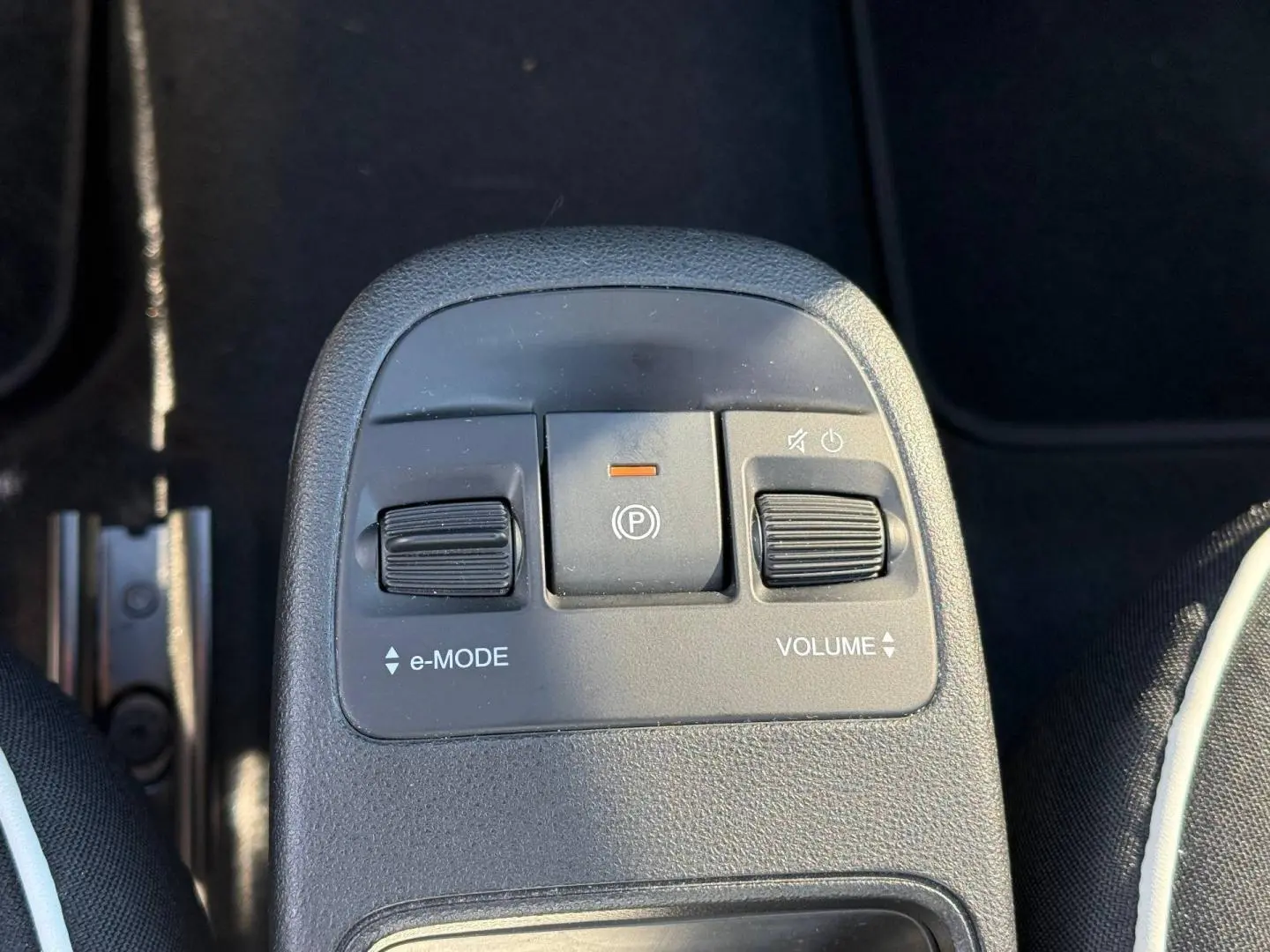 Gros plan sur la console centrale de la Fiat 500 électrique jaune MY24, montrant les commandes e-MODE et volume.