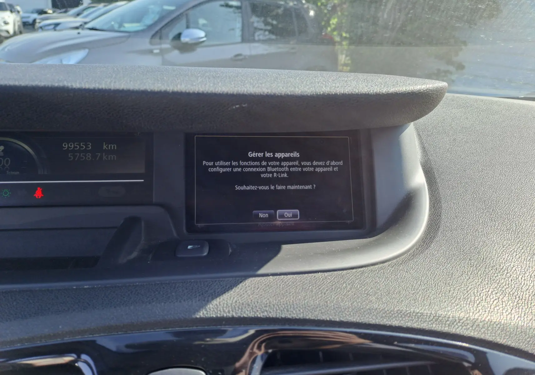 Tableau de bord du Renault Scenic III gris 2016, affichant l'écran central avec menu Bluetooth et compteur kilométrique.