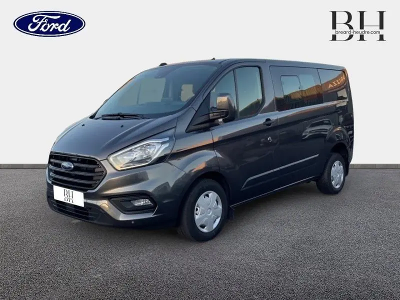 Fourgon Ford Transit Custom gris magnétic métallisé vu en 3/4 avant droit sur fond neutre.
