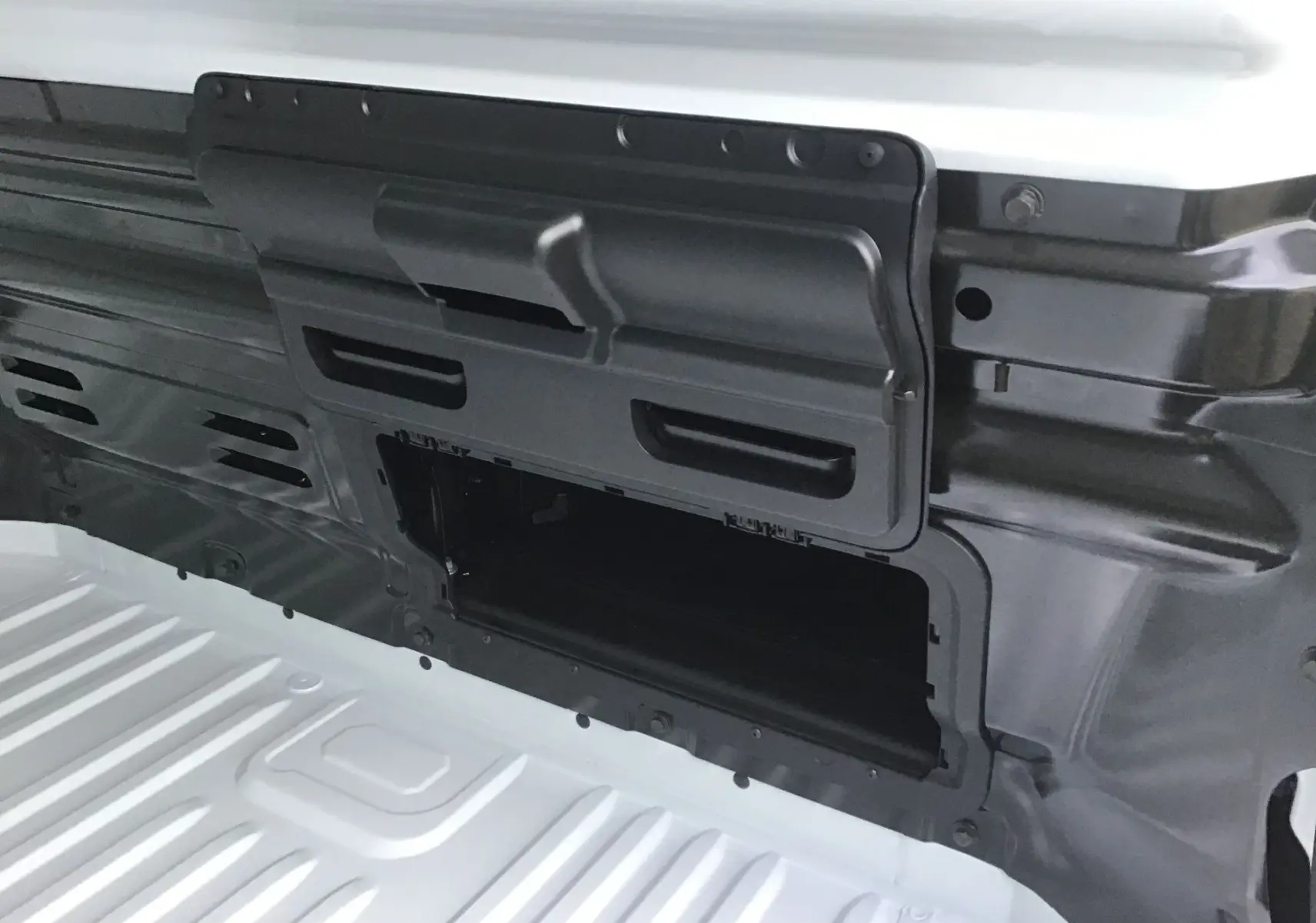 Détail de la cloison avec trappe de charge longue ouverte sur le Renault Trafic Fourgon blanc, vue intérieure.