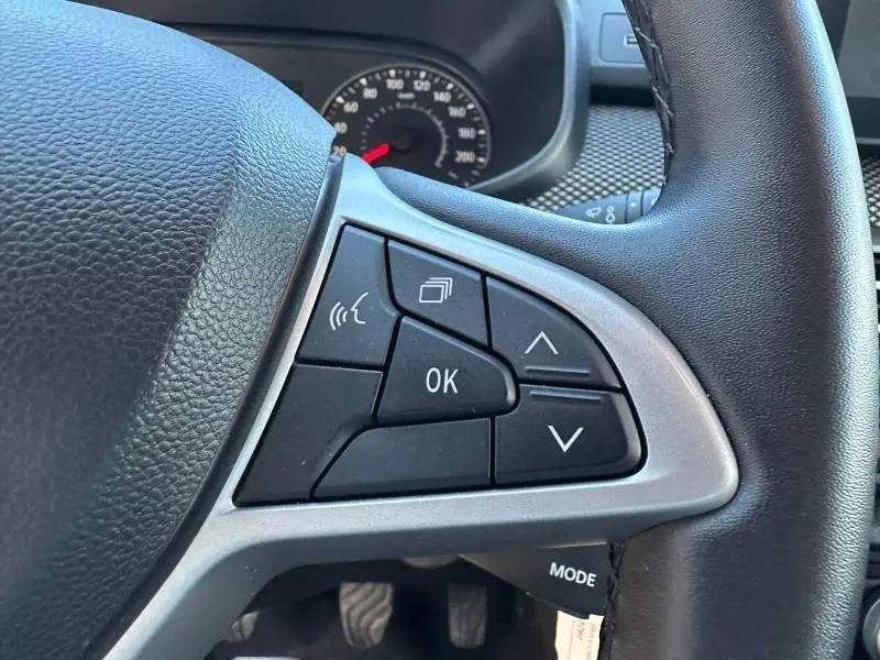 Gros plan sur les commandes au volant du Dacia Jogger 2025, boutons multifonctions noirs avec contour argenté.