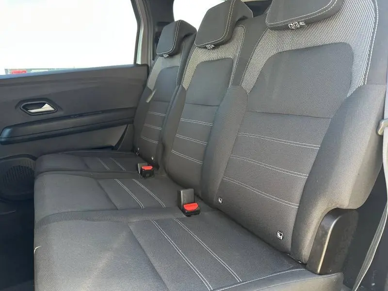 Vue latérale des sièges arrière noirs du Dacia Jogger 2025, version 7 places, avec appuie-têtes et ceintures visibles.